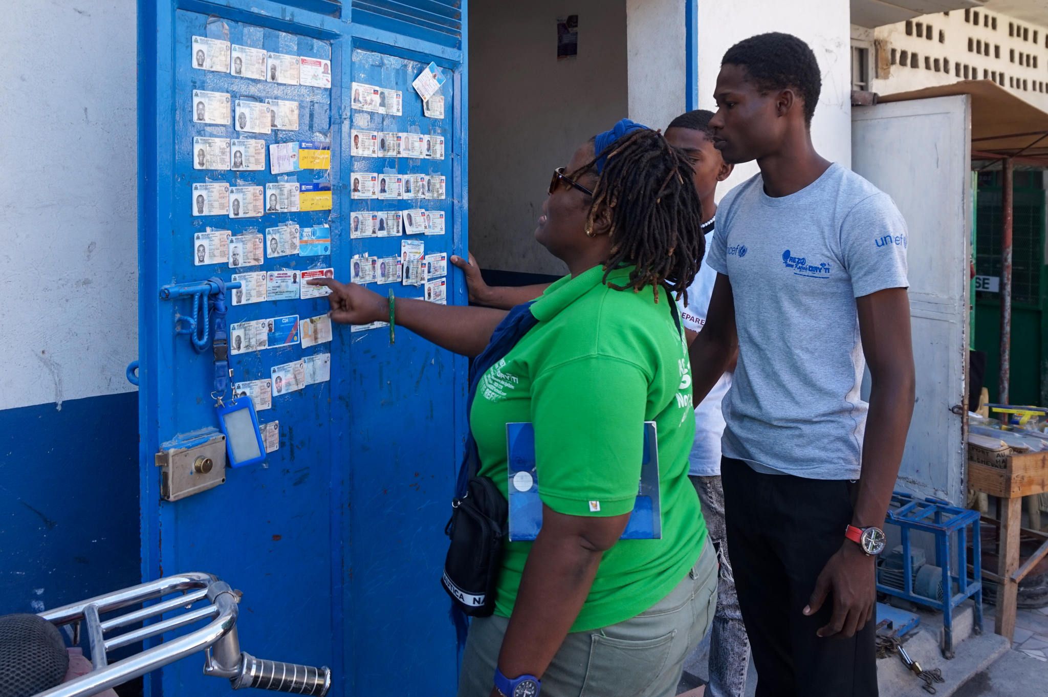 People checking for their ID cards posted on a door in Haiti